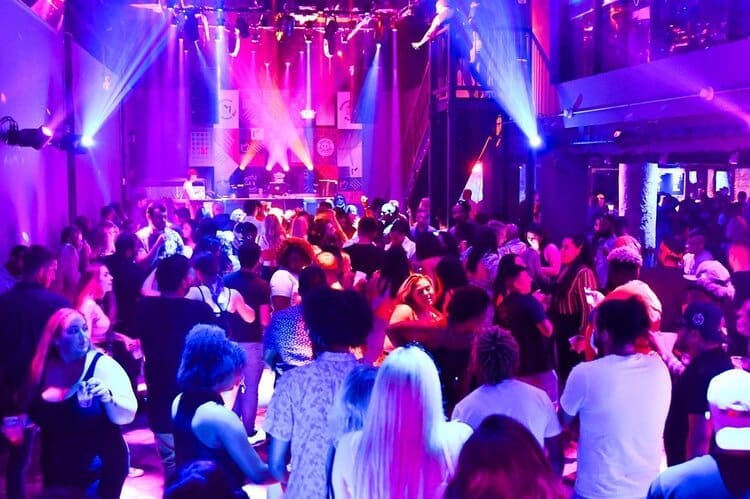 People dancing under bright colored lights